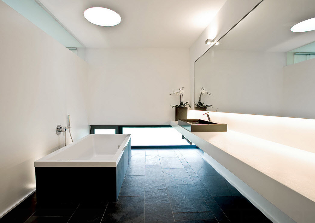 Beyaz duvarlı bir banyoda koyu renkli yer karoları
