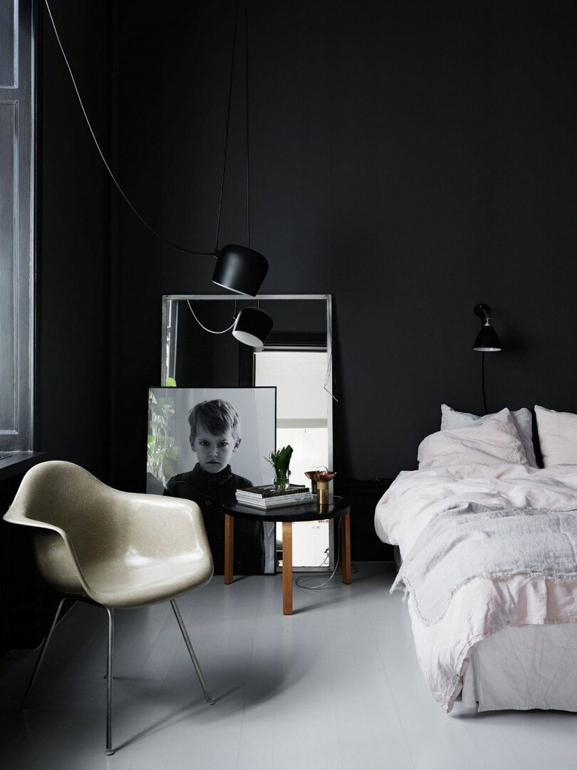 Yatak odasında siyah bir duvarın yanında bir çocuğun portresi