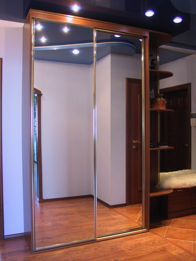 Sliding wardrobe with mirrored doors in the corridor of the apartment