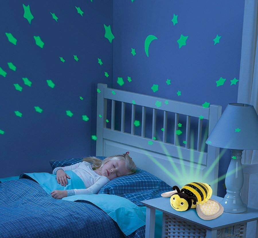 Guļošs bērns istabā ar projektora nakts gaismu