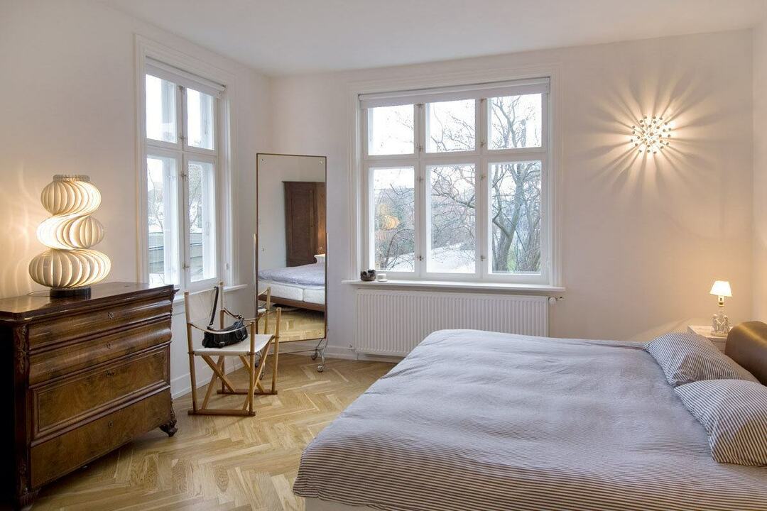 Iluminación del dormitorio sin cortinas en las ventanas.