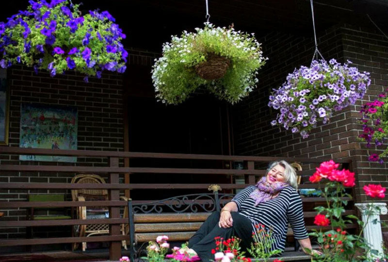 Om sommeren er terrassen dekorert med potter med rikelig blomstrende planter
