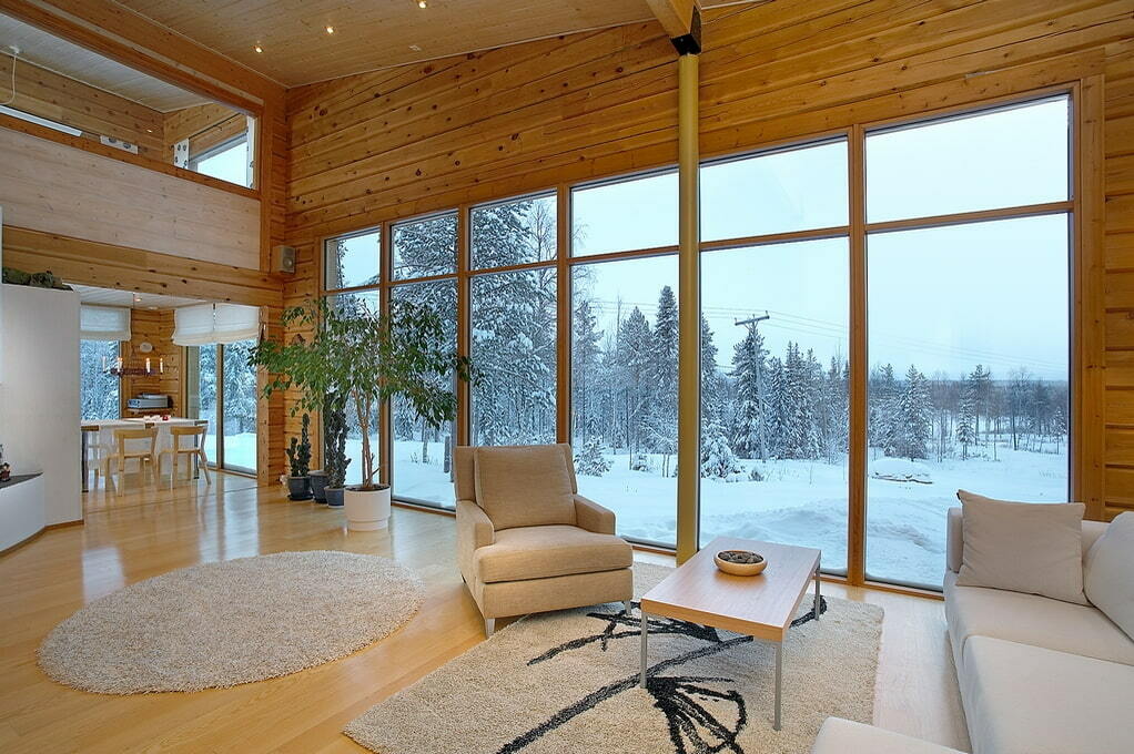 Grande janela panorâmica na sala de estar de uma casa de madeira