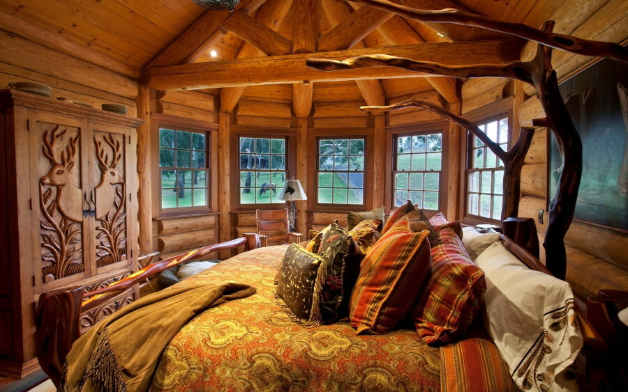 Dormitorio con ventanal en una casa de troncos