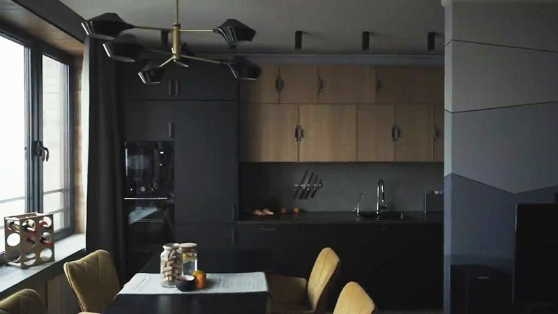 Über dem Esstisch hing ein Designer-Kronleuchter mit schwarzen Glasschirmen, Metallstrahler erhellen den Arbeitsbereich