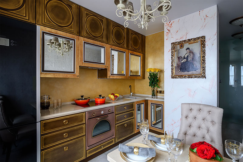 Der Retro-Style Backofen in Kupferfarbe und das schwarze Glaskeramik-Kochfeld fügen sich perfekt in das stilvolle Interieur der Küche ein