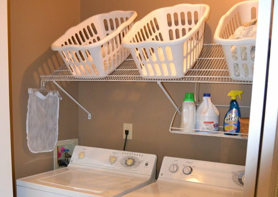 Plastikowe skrzynki na przechylonej półce w domowej pralni