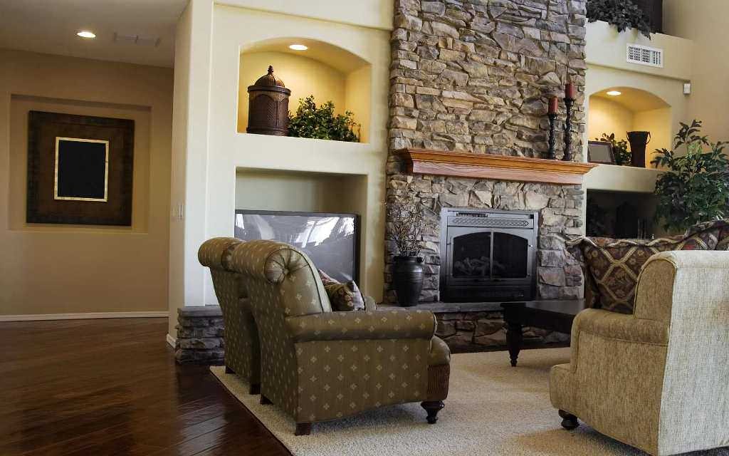Comfortable armchairs in front of a raised fireplace in the living room