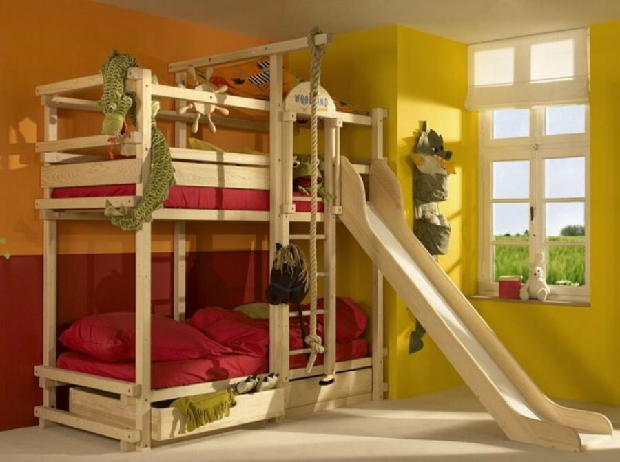 Łóżko ze zjeżdżalnią w rogu dziecięcej sypialni