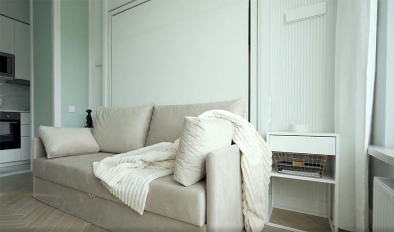 Enfrente, un sofá con almohadas suaves cabe cómodamente