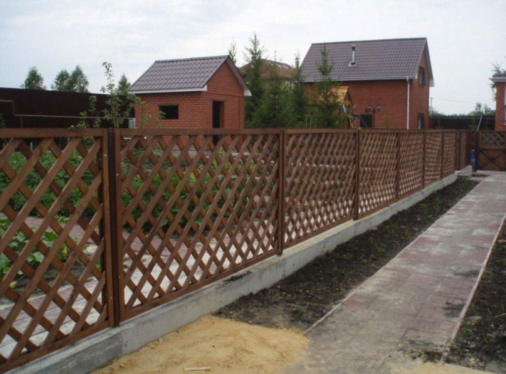 A fence made of a wooden picket fence, boards or blinds in the landscape design of the cottage