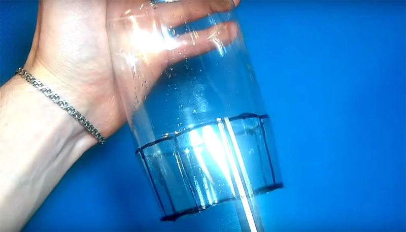 Bunnen av flasken skal kuttes av, og plasten skal kuttes langs de vertikale linjene med ca 4-5 cm
