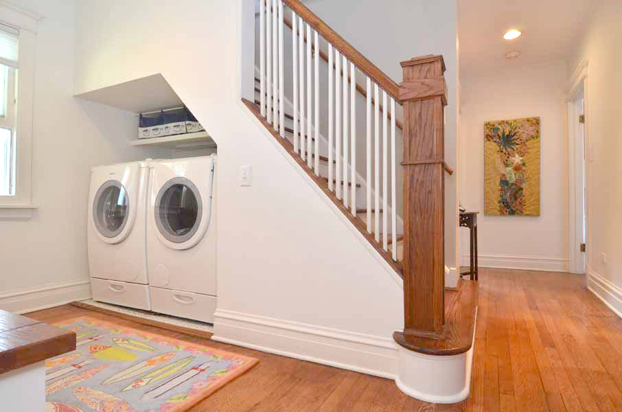 Çatı katı olan bir evde merdivenlerin altında çamaşır makinesi