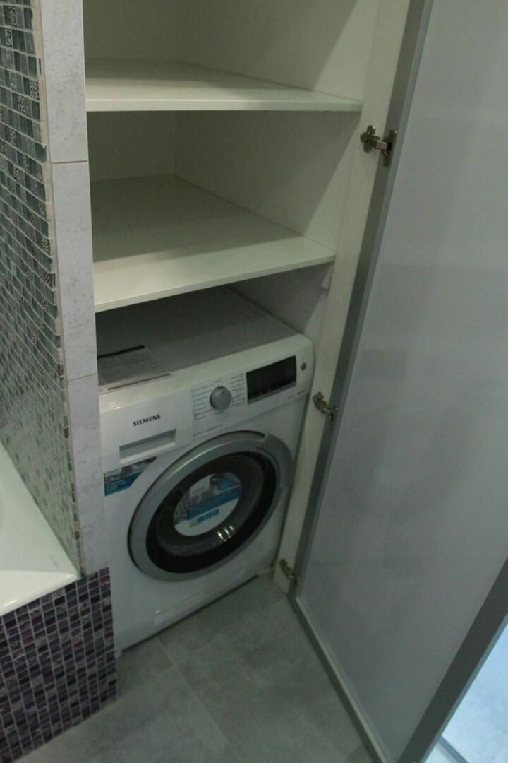מכונת כביסה בנישה של קיר האמבטיה