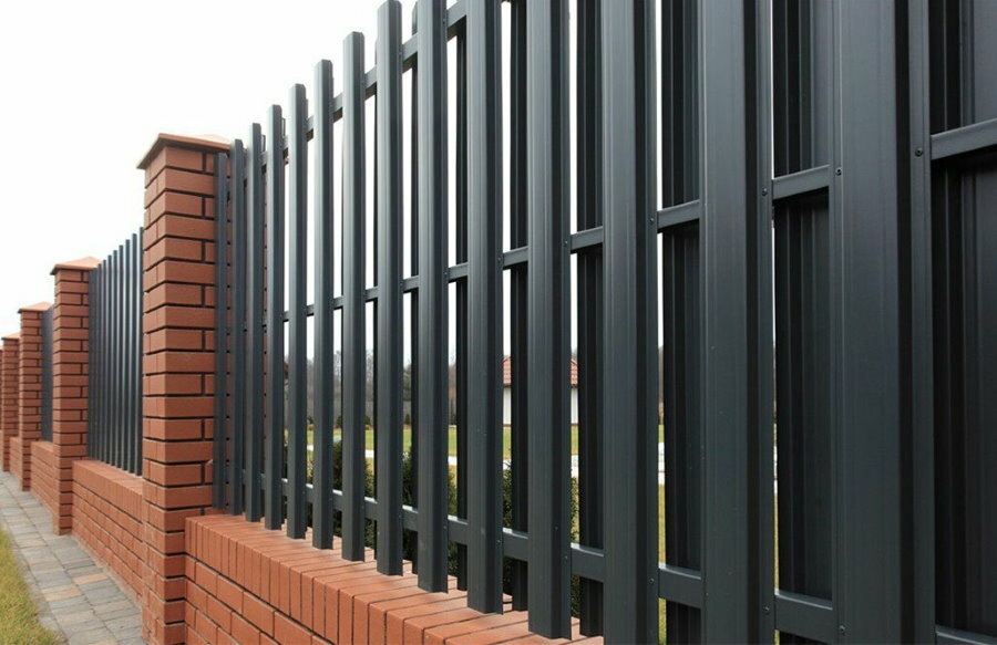 Black fence made of metal picket fence on a profile pipe