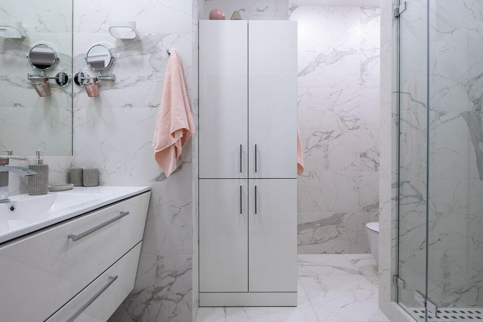 Valkoinen kylpyhuonekaappi, jossa marmorilaatat