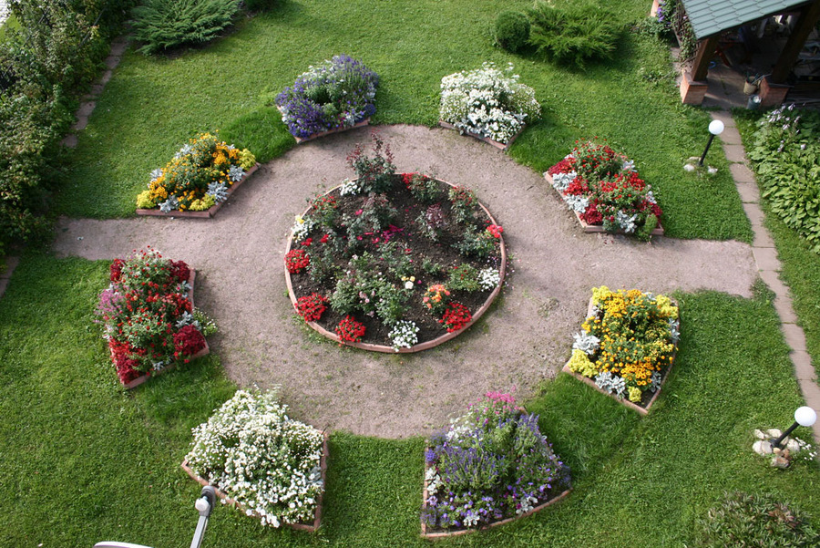 Symmetrical design of the flower garden in front of the house