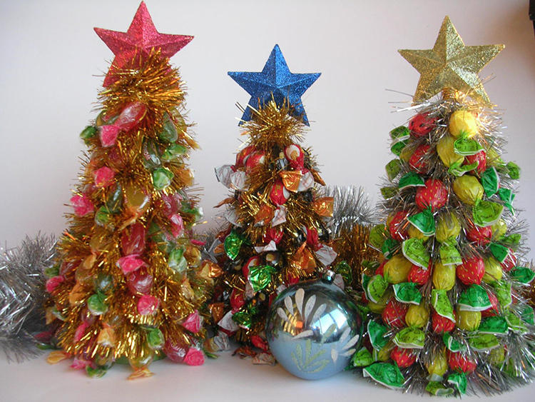 Lihtsaim variant on kristalliseerunud jõulupuud. Nende valmistamiseks vajate papist koonust, taldrikut ja kommid ise heledates pakendites.