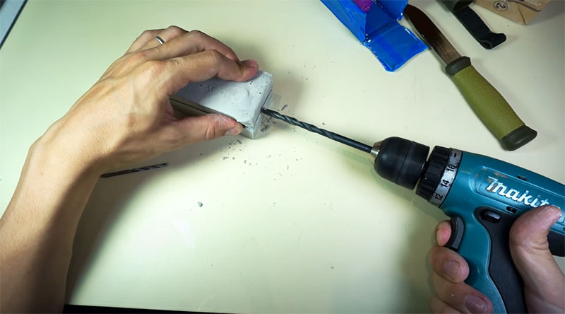 Using a drill, a hole is made for pouring aluminum