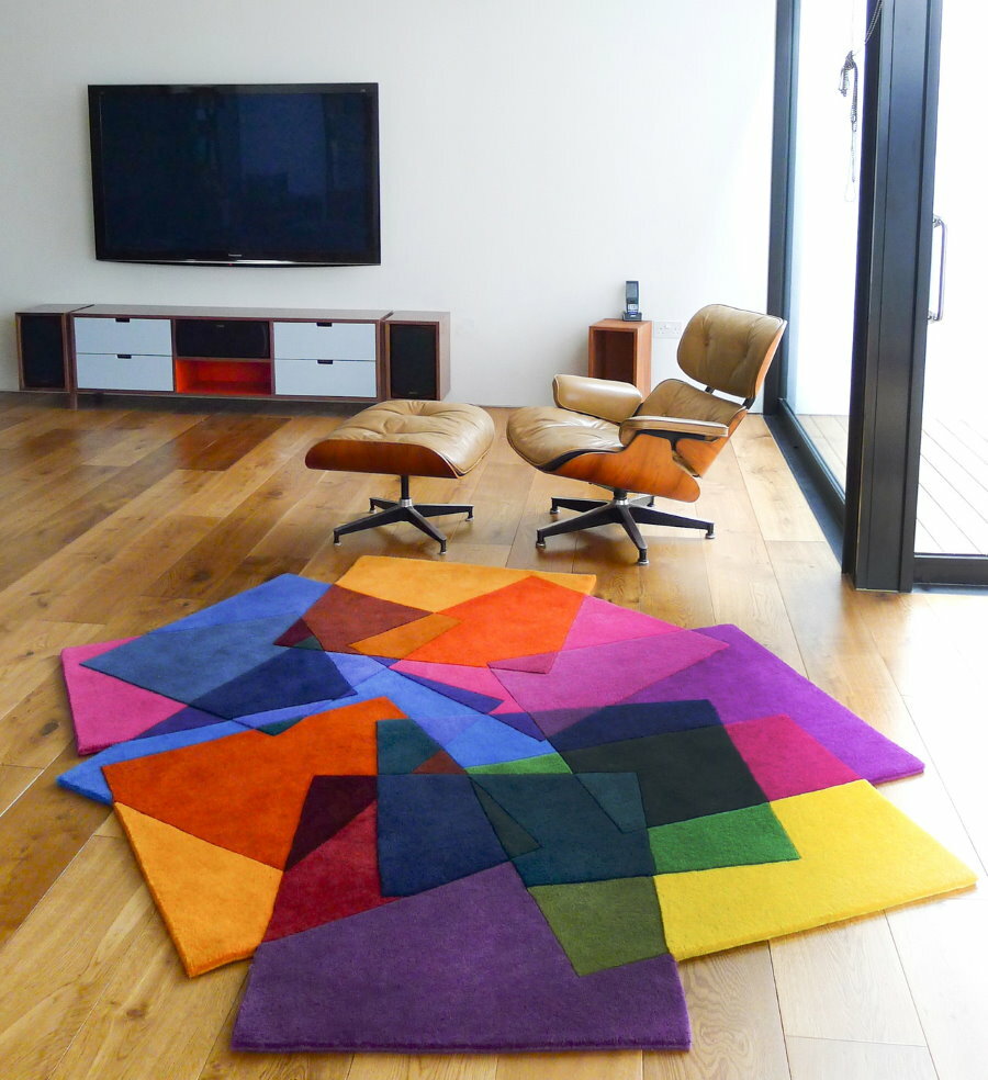 Įvairių geometrinių formų kilimas privataus namo salėje