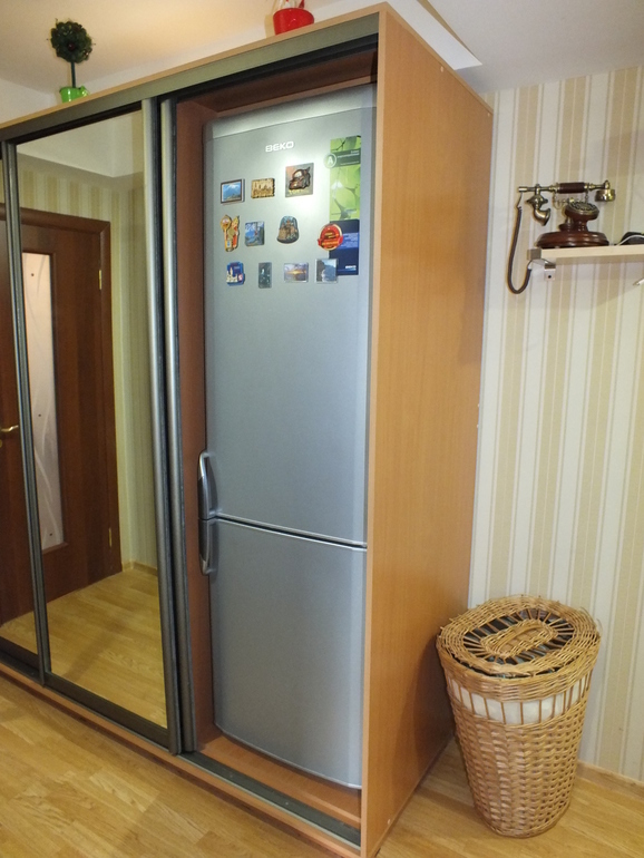 Högt kylskåp i en garderob av typfack