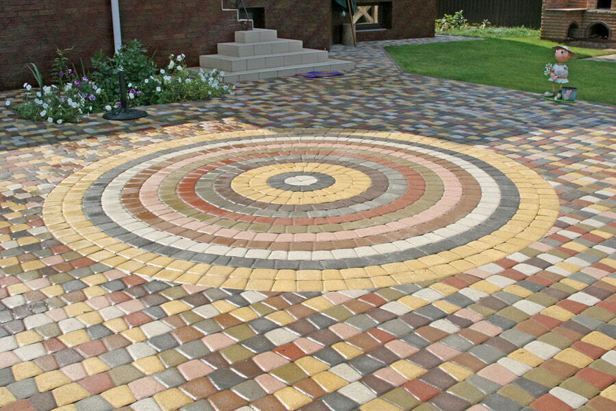 Mozaikové kladenie farebných dlaždíc v záhrade