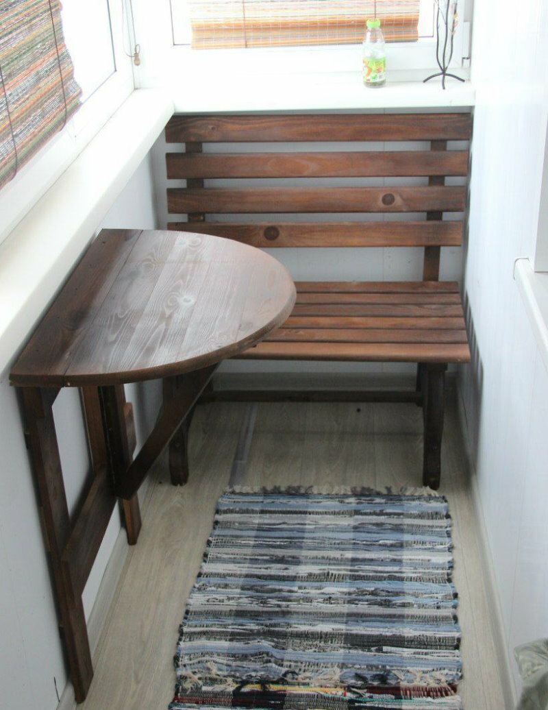 Wooden bench near the folding table on the balcony