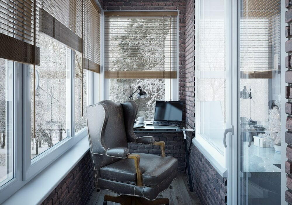 Bürostuhl aus Leder auf dem Balkon eines Backsteinhauses
