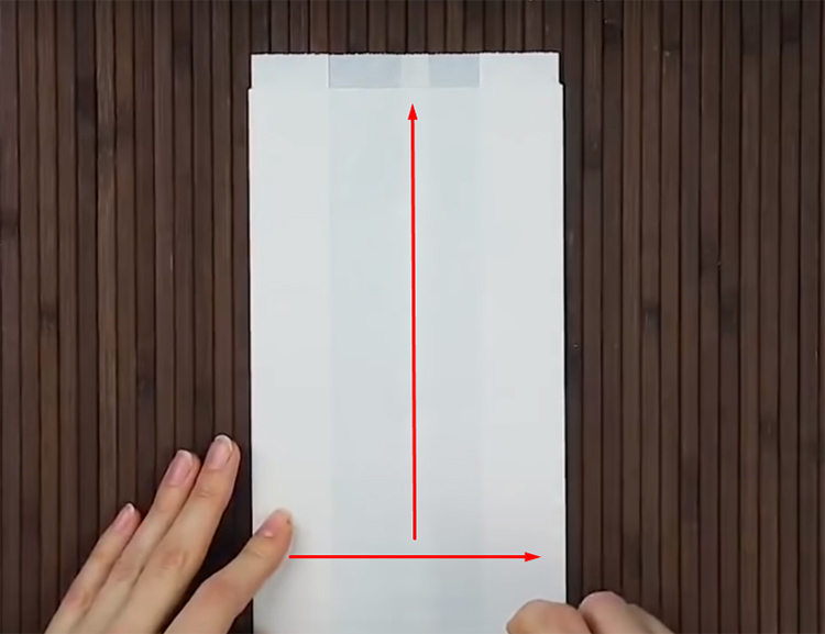 Presavijte list papira u traku, presavijte po rubovima, a zatim na pola. Nanesite ljepilo duž linija označenih strelicama