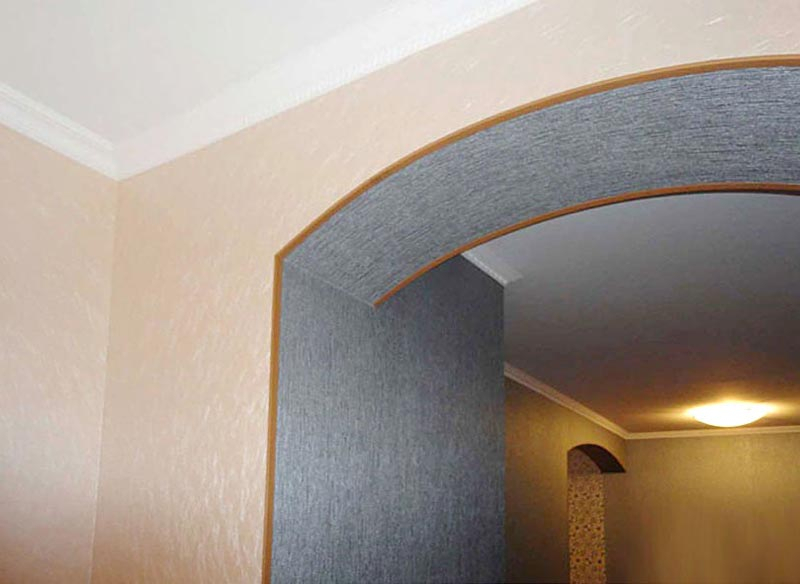 Pasting the arch with vinyl wallpaper for decorative plaster