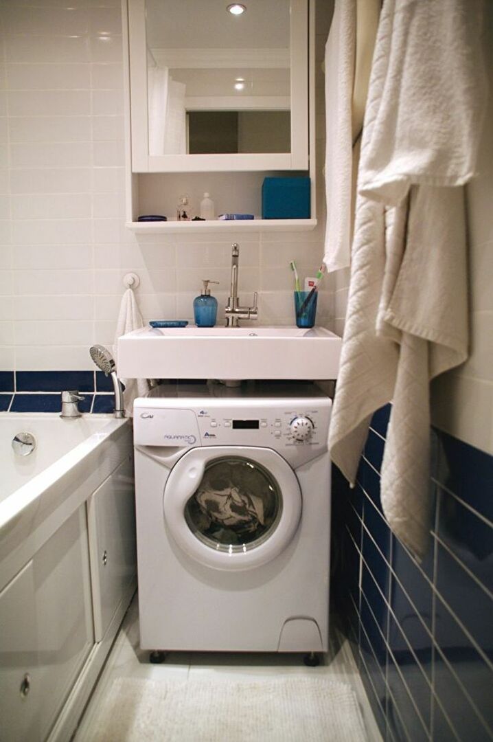 Kare bir lavabonun altında bir çamaşır makinesinin dar modeli