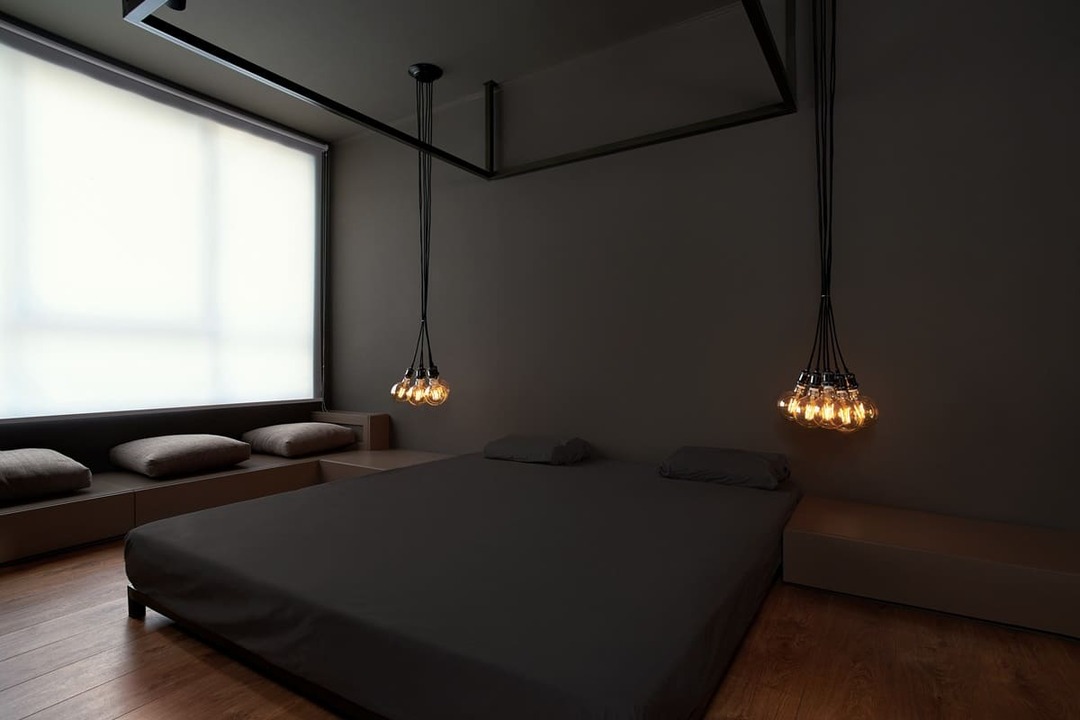 Lámparas colgantes en un dormitorio con paredes oscuras.