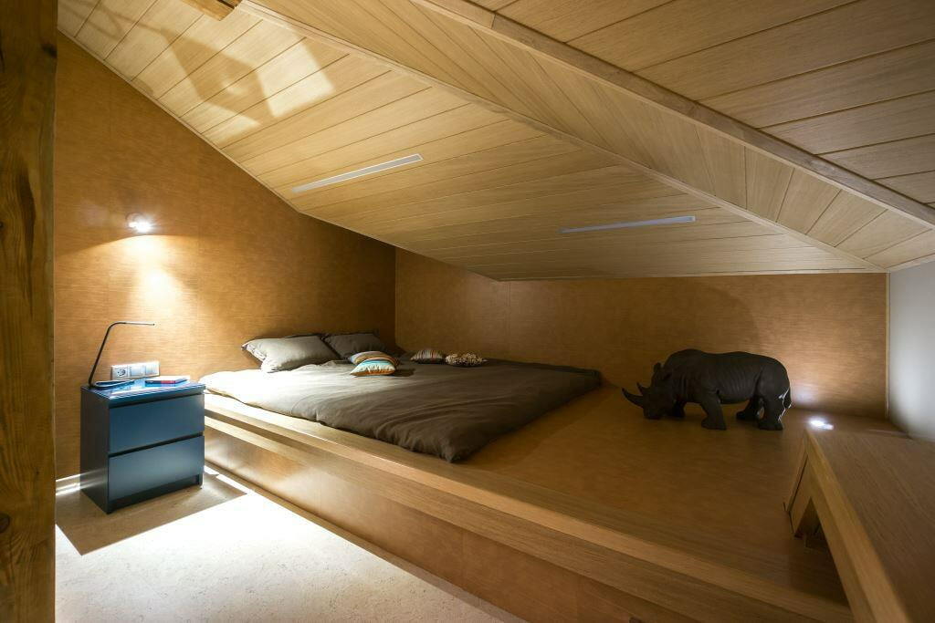 Lavt pallplass med seng på soverommet på loftet