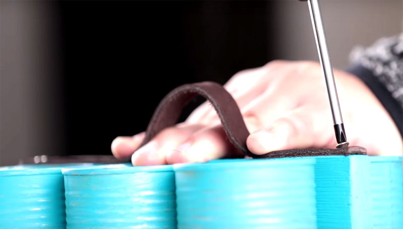 Uma pulseira de couro é presa à borda da tira para 2 parafusos auto-roscantes, de modo que uma alça permaneça, que será conveniente agarrar com a mão