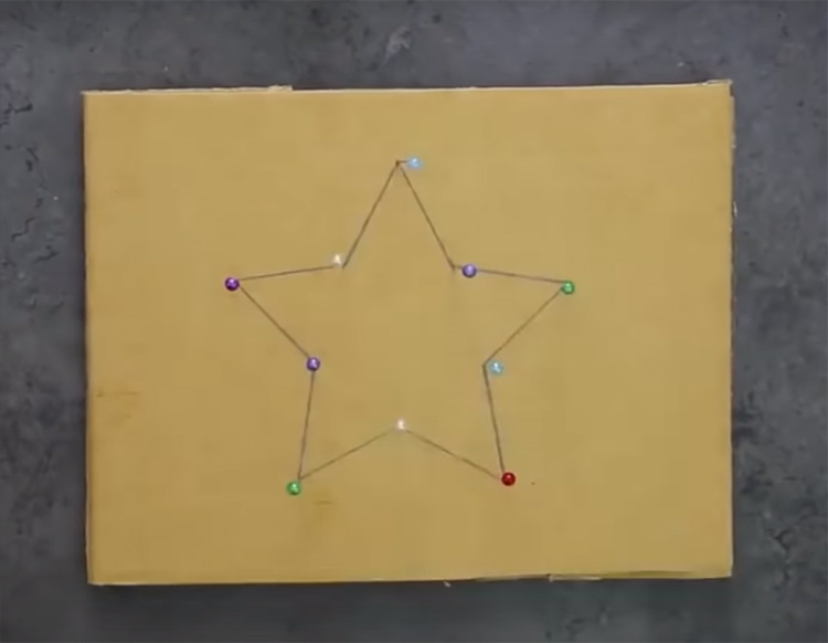 Uz kartona gabala uzzīmējiet zvaigzni un staru virsotnēs piestipriniet tapas.