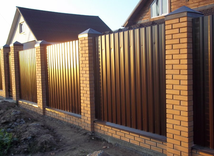 Brown corrugated sheet between brick pillars on the fence