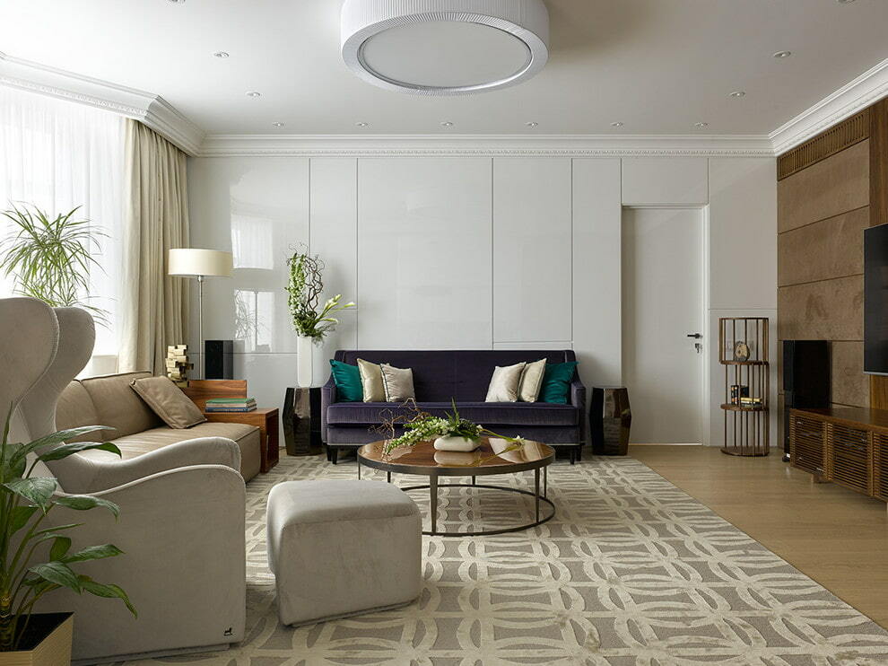 Tmavě fialová pohovka proti bílé zdi v obývacím pokoji