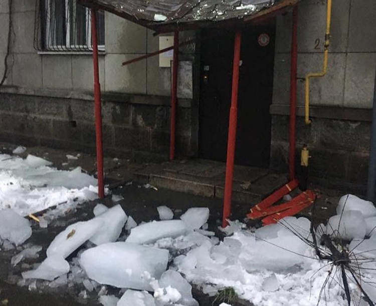 Rikkoutunut antenni ja katkennut kuisti, kun lumi on poistettu talon katolta