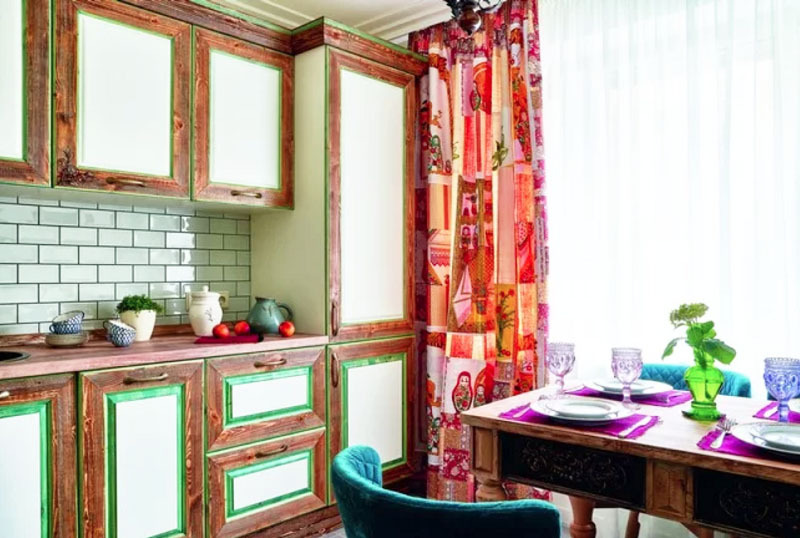 Los delicados bordes verdes de los gabinetes se hacen eco de la madera natural y las cortinas brillantes.