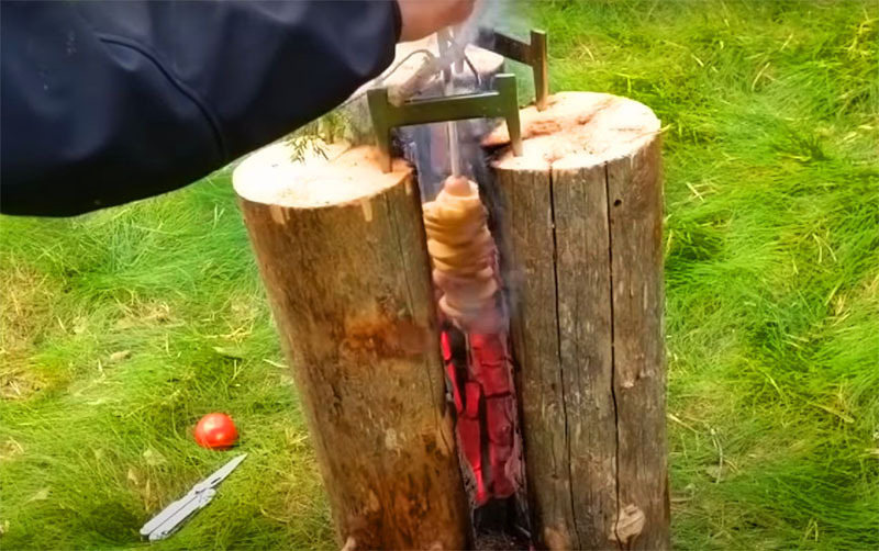To position the skewer exactly in the center of the vertical barbecue and not accidentally fry it against one of the smoldering walls, a partition should be laid between the brackets. The skewer is placed on it.