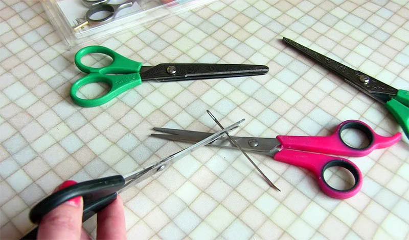 For at slibe saksen skal du bare lave et par skærebevægelser langs nålen. Hold nålen på vægten parallelt med bordet, og kør knivene i 30-40 sekunder langs den i hele længden