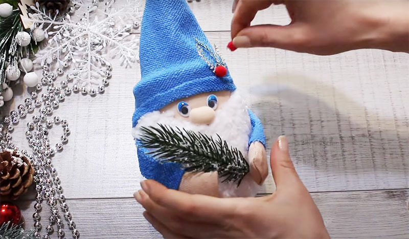 To decorate the New Year's gnome, use coniferous twigs, Christmas decorations, beads and feathers