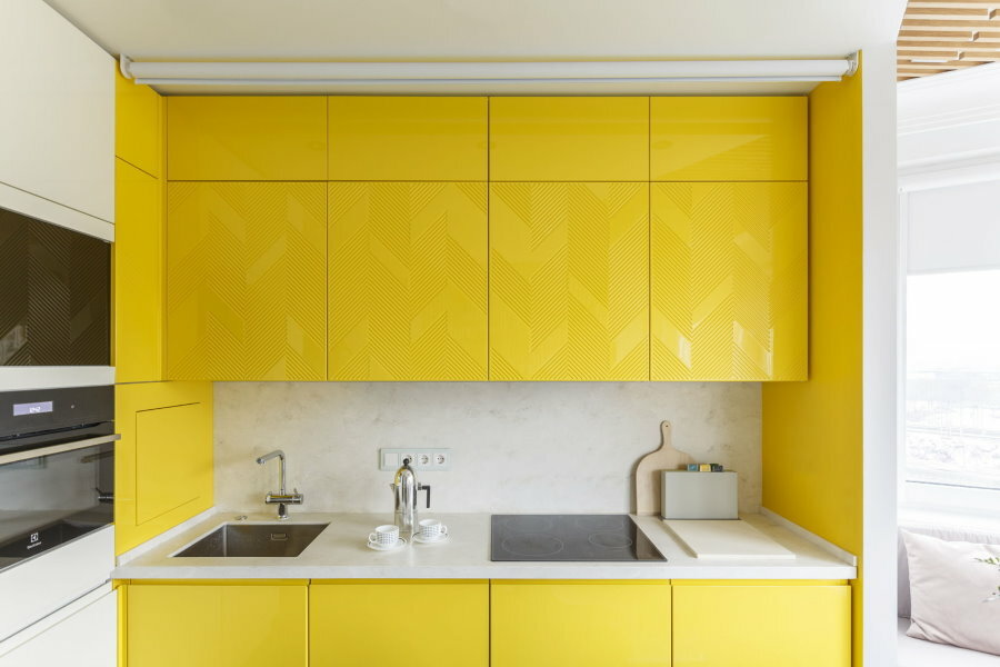 Malá vybavená kuchyň se žlutými dveřmi