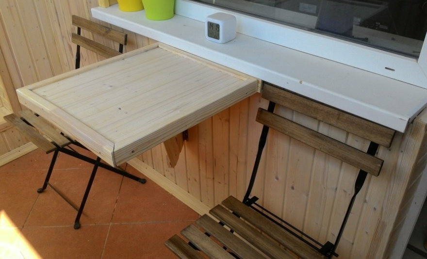 Table pliante en bois sous un rebord de fenêtre en plastique