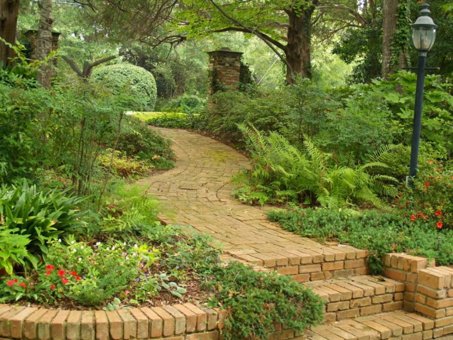 Bakstenen pad diep in een tuin in natuurlijke stijl