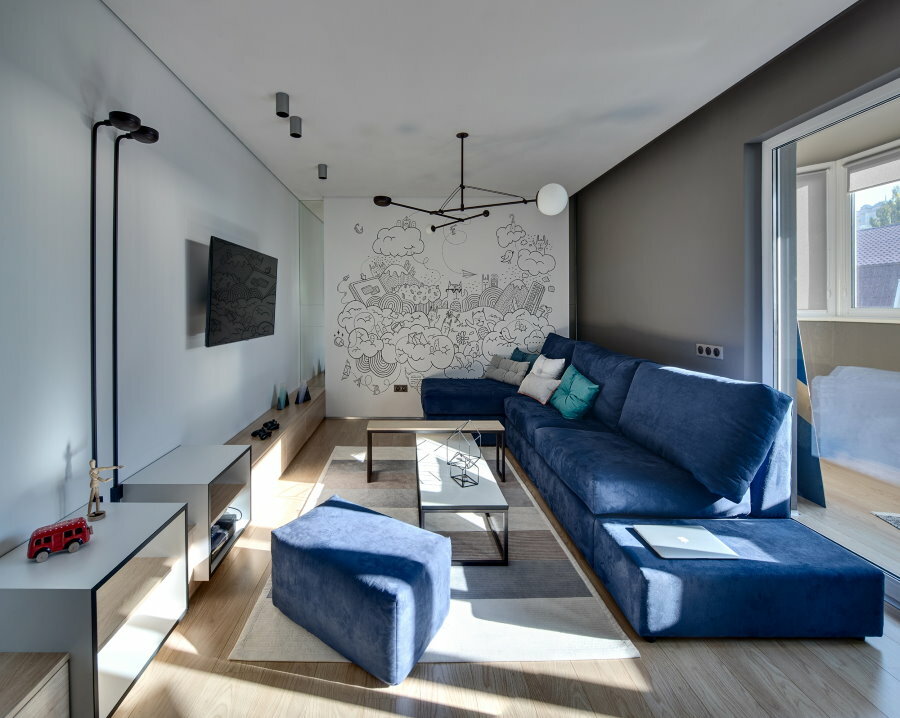 Zils dīvāns vīriešu studijas tipa dzīvoklī