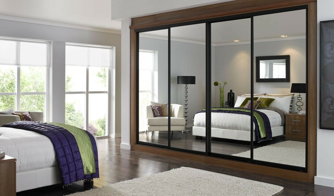 built-in wardrobe in the bedroom with a mirror