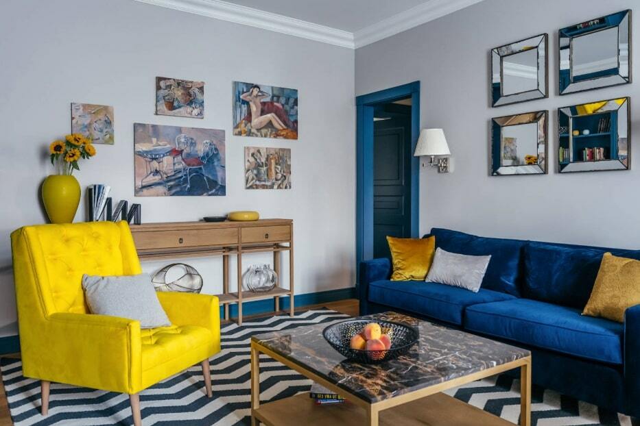 Gul lænestol overfor den blå sofa i stuen