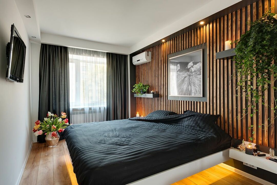 Drewniane listwy na ścianie sypialni z czarnymi zasłonami