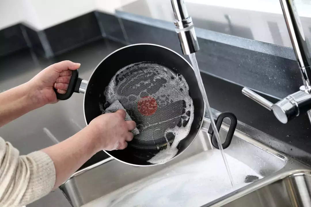 casserole en téflon sous le robinet
